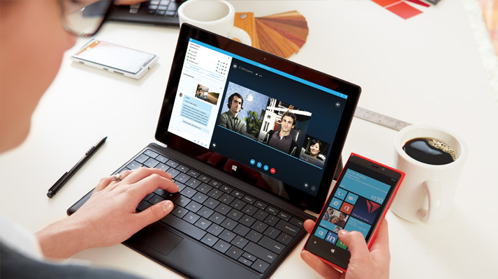 Eine Frau verwendet Office 365 auf einem Tablet und Smartphone, um Dokumente gemeinsam mit anderen zu bearbeiten.