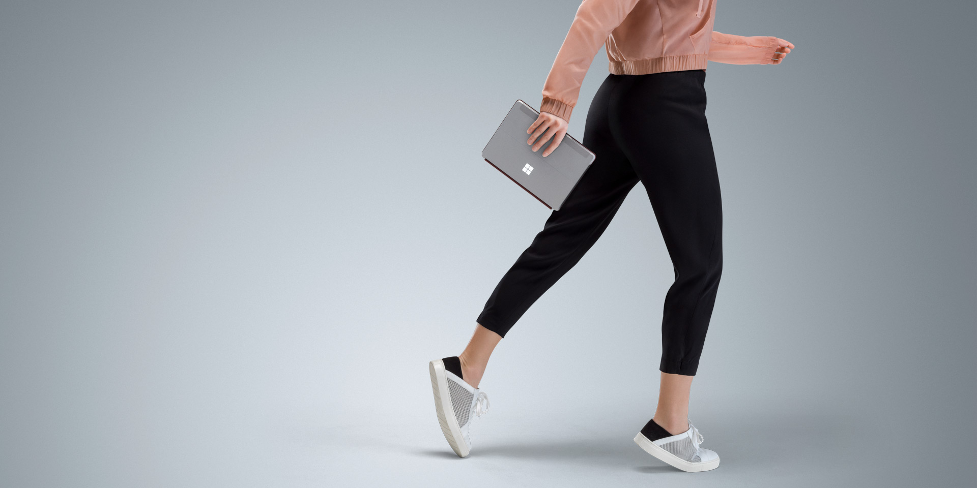 Surface Go in a woman’s hand as she walks