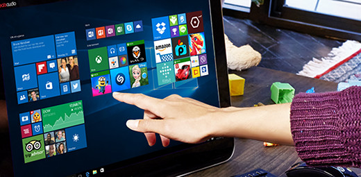 A woman’s hand preparing to touch an app tile on a touchscreen computer