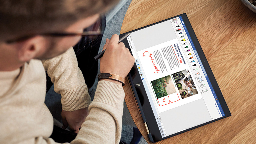 Man using digital pen edits a Word document on a 2-in-1 Windows 10 device
