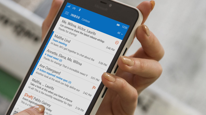 A hand tapping a message in an Office 365 email list on a smartphone.