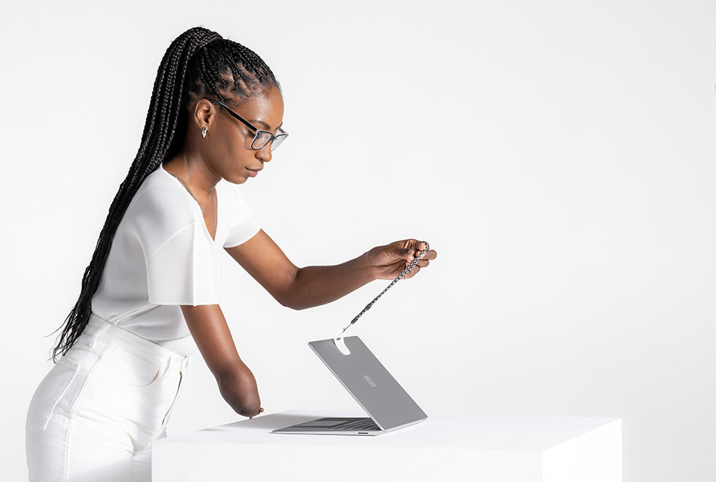 A person using the Surface Adaptive Kit to open Surface Laptop Studio.