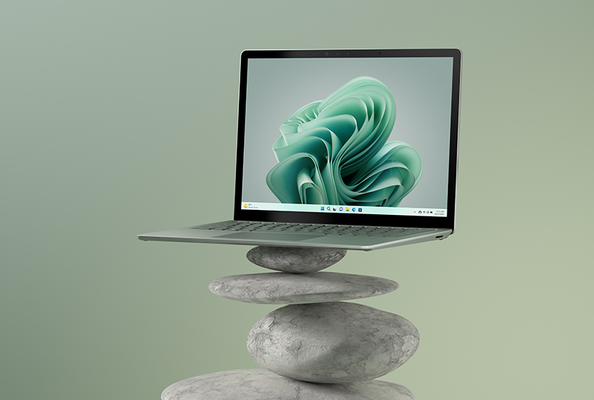 Surface Laptop 5 in sage is sitting on top of a cairn.