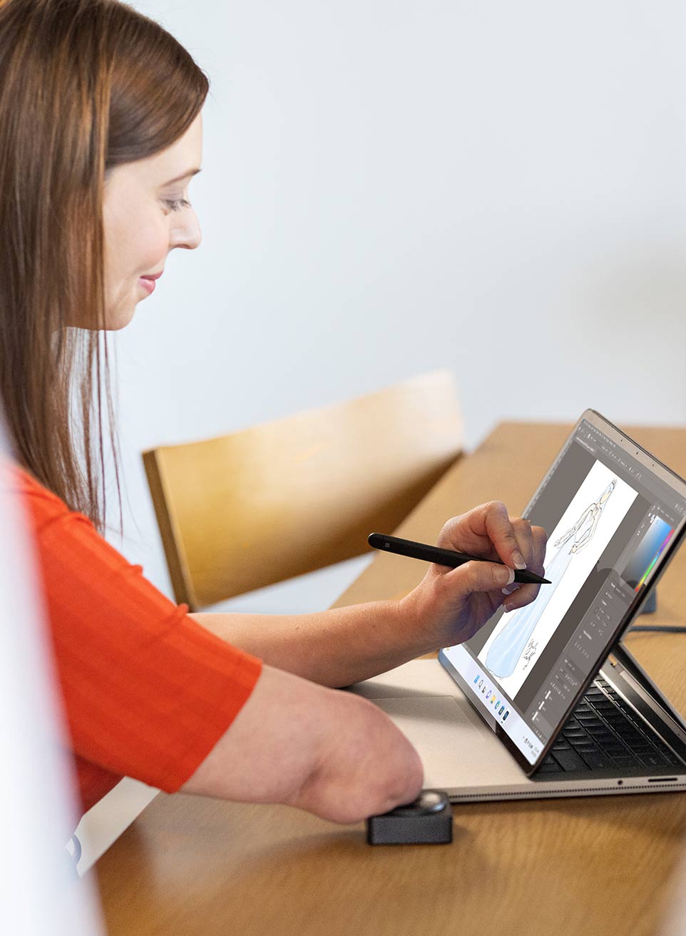 A woman sketches on her Surface Laptop Studio to design a dress for herself.