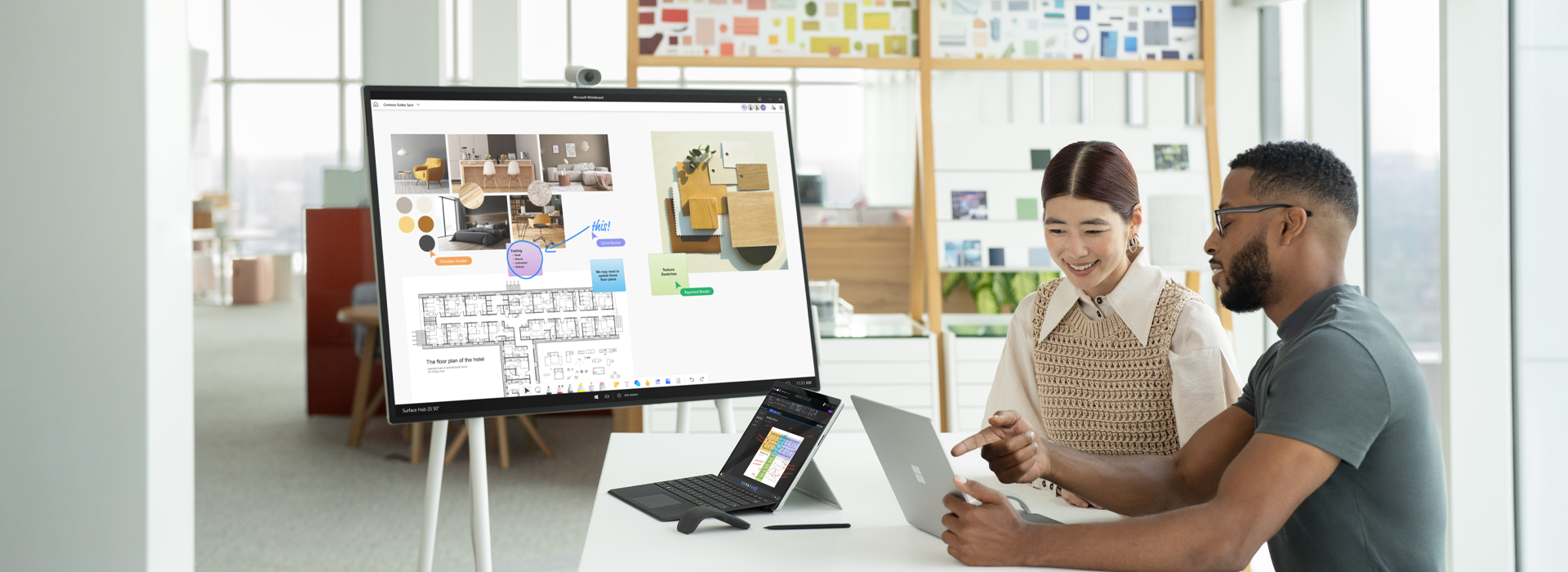 Due colleghi che interagiscono con due dispositivi Surface Laptop 5 e un a dispositivo Hub 2S sullo sfondo