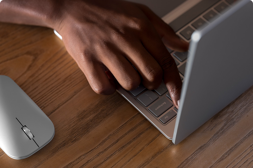 Palec naciskający klawisz na laptopie w celu zalogowania się za pomocą odcisku palca