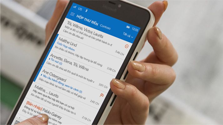 Một bàn tay đang nhấn vào một thư trong danh sách email Office 365 trên điện thoại thông minh.