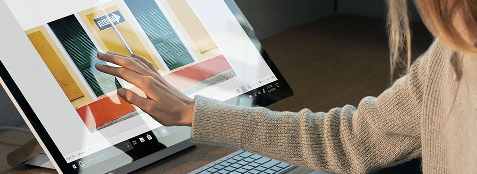 一位女士正在使用 Surface Studio 的触摸屏