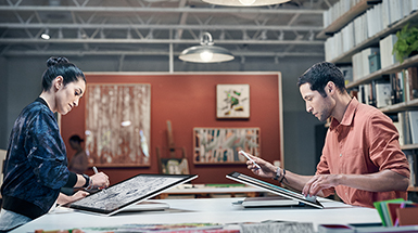 男人和女人面對面使用工作室模式的 Surface Studio 工作
